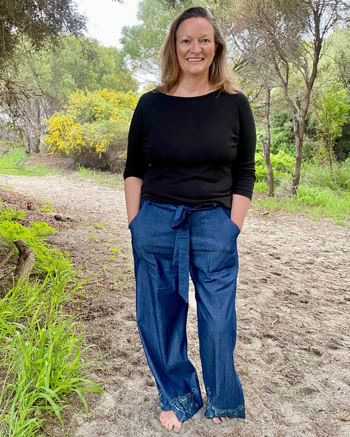 Women's wide-leg beach pants with a tie waist and hammerhead shark motif embroidered cuffs and generous pockets.