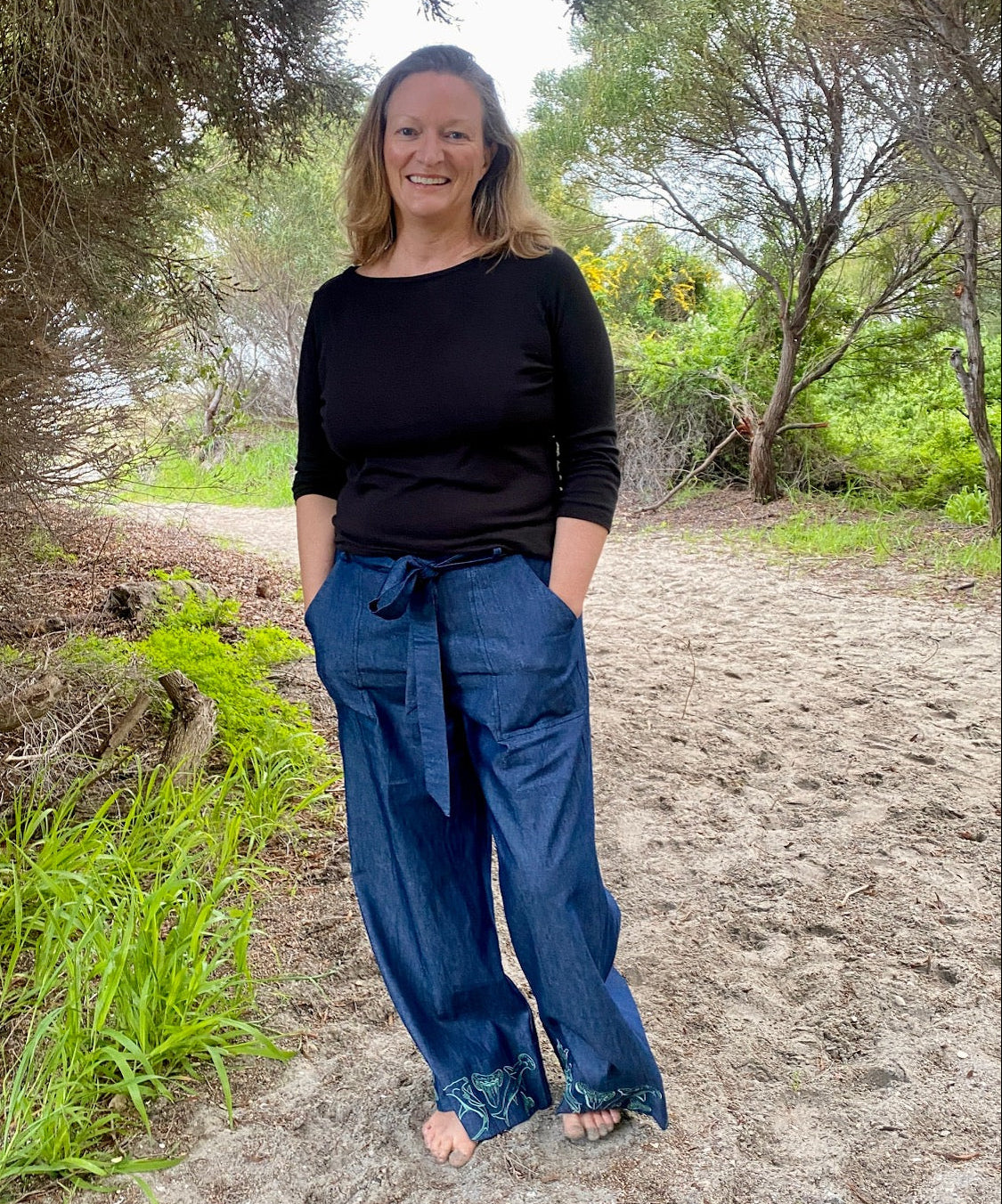 Women's wide-leg beach pants with a tie waist and hammerhead shark motif embroidered cuffs and generous pockets.
