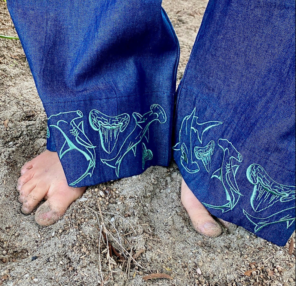 Embroidery detail of hammerhead shark motif on cuff of Women's wide-leg beach pants with a tie waist and generous pockets.