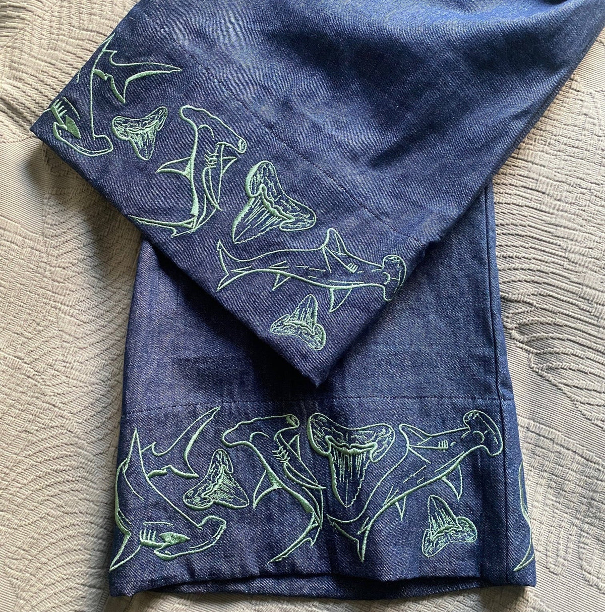 Women's wide-leg beach pants with a tie waist and hammerhead shark motif embroidered cuffs and generous pockets.