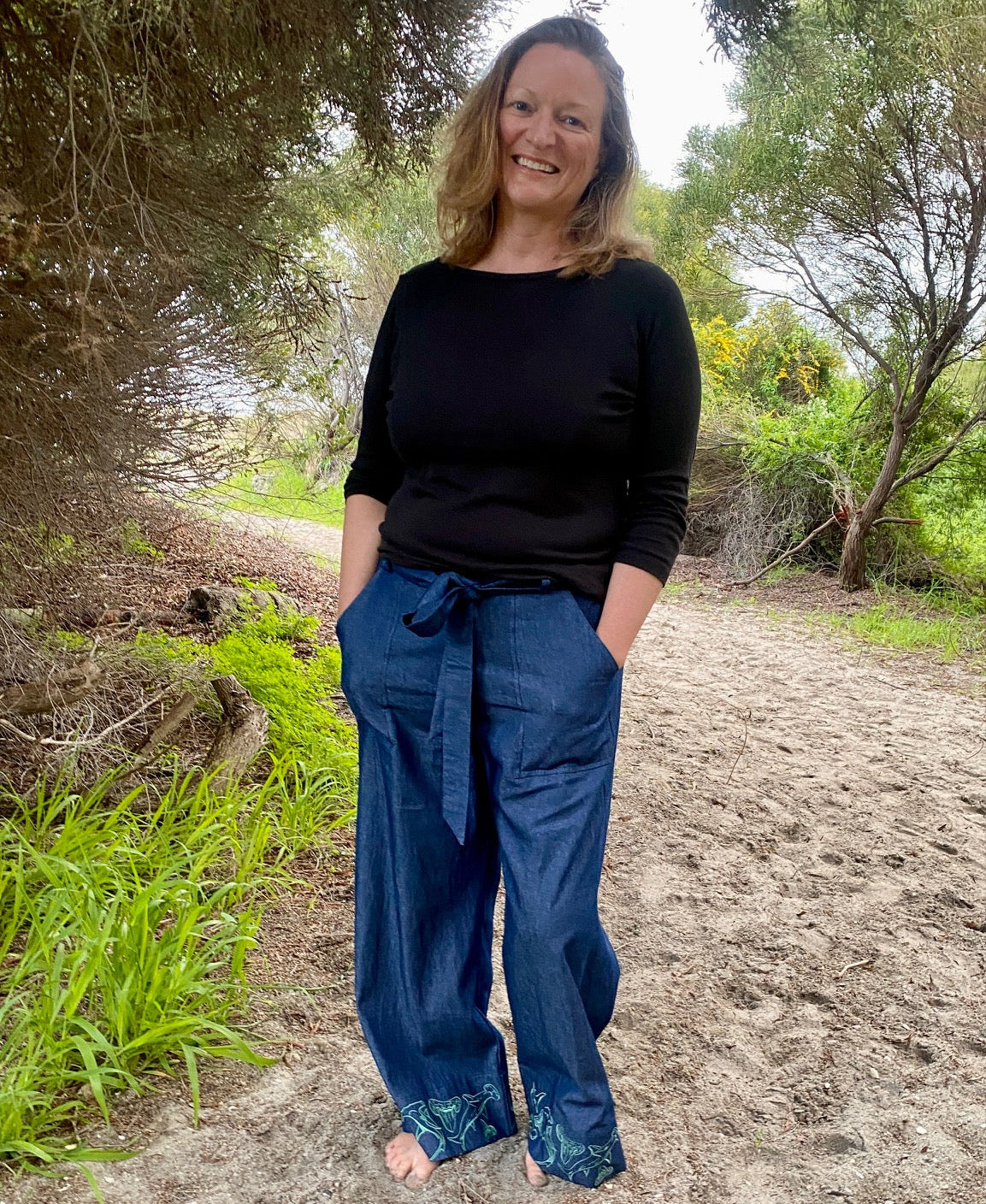 Women's wide-leg beach pants with a tie waist and hammerhead shark motif embroidered cuffs and generous pockets.