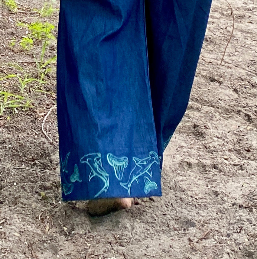 Women's wide-leg beach pants with a tie waist and hammerhead shark motif embroidered cuffs and generous pockets.